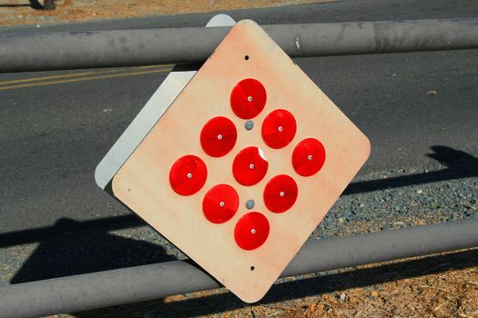 Bright red reflectors on a caution sign.
