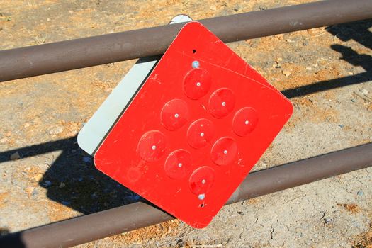Bright red reflectors on a caution sign.
