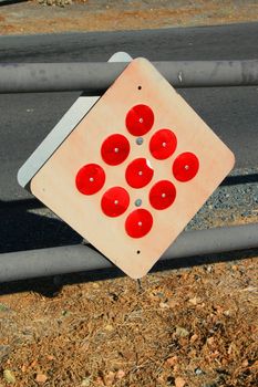 Bright red reflectors on a caution sign.
