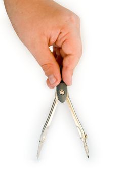 Children's hand with a metal compasses on a white background