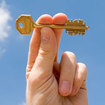 hand transfers the key with sky at background