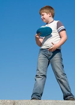 little boy playing frisbee with sky at background