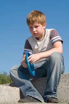 little boy playing frisbee with sky at background
