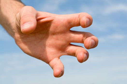 Human hand on a blue sky