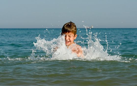 A little boy playing at the sea