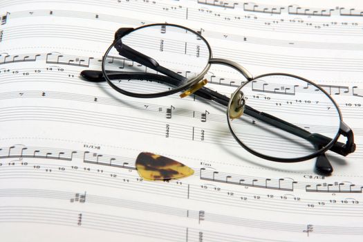 education concepts study music spectacles on a music book and guitar pick