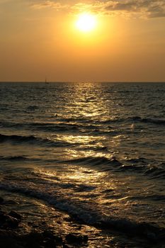 Sea waves with sunset at background