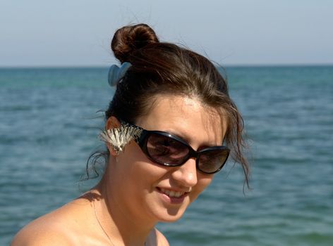 Beautiful Young Woman on the Beach.  live butterfly on the face.