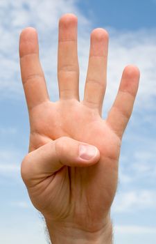 Four. Human hand on a blue sky