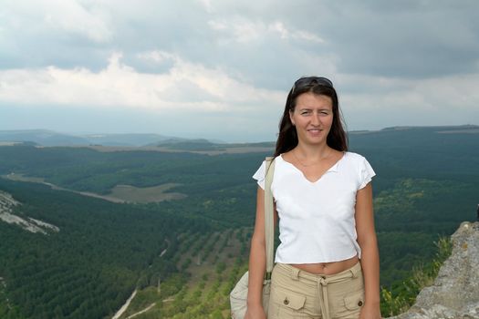 young beautiful woman against a mountain valley