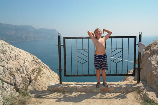 little boy against mountains and the sea