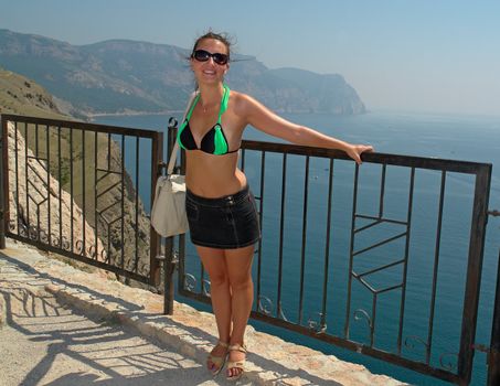 young beautiful woman against  mountains and the sea