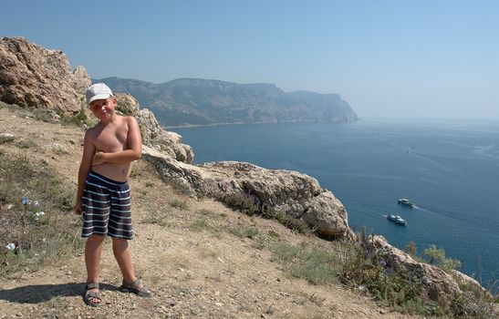 little boy against mountains and the sea