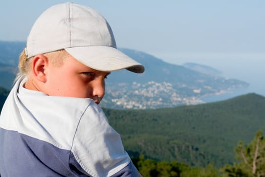 little boy against mountains and the sea