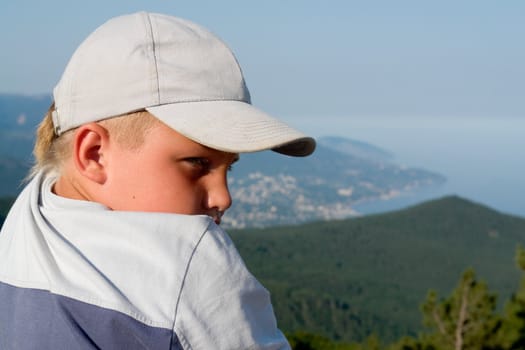 little boy against mountains and the sea