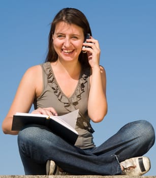 beautiful girl taking notes on a sky background