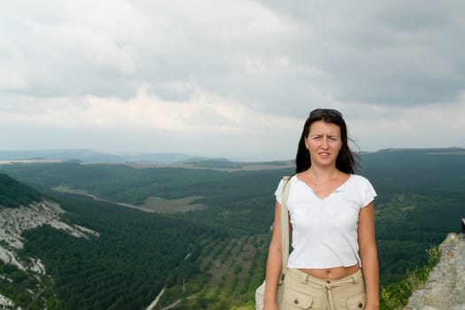 young beautiful woman against a mountain valley