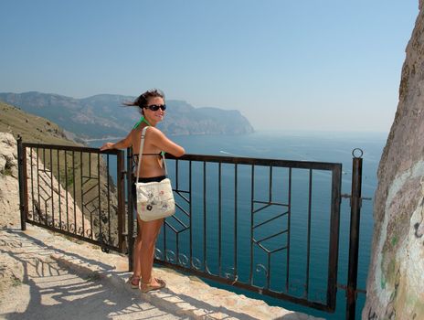 young beautiful woman against  mountains and the sea