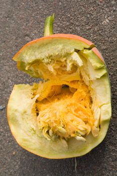 Half of broken pumpkin on asphalt