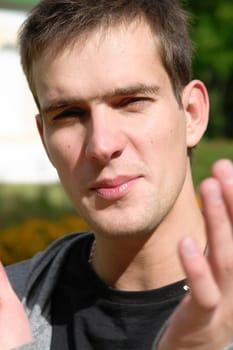 Portrait of the young man in a sharp sunlight