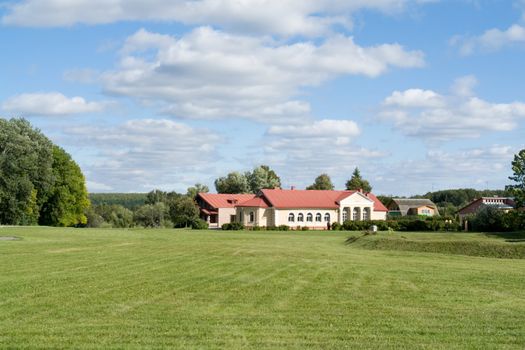 Rural landscape. The beautiful house on a green meadow.
