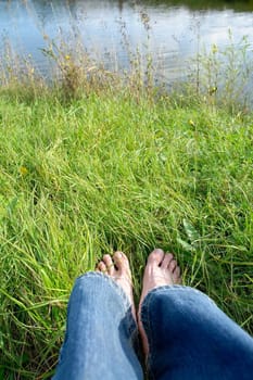 Silence. Photographer sits on green river coast.