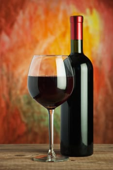 Wine, glass and the bottle on a colored background