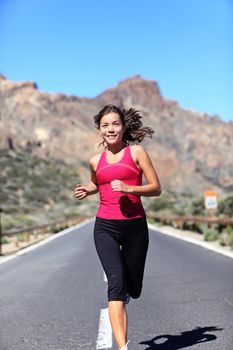 Jogging woman. Female runner outdoors running workout in mountain landscape. Beautiful mixed race Caucasian / Chinese Asian female athlete model working out outside.