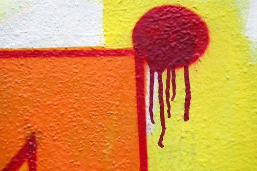 Abstract dripping graffiti detail on textured wall. Urban street art background.