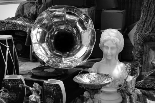 Vintage gramophone and antique objects at street fair. Black and white.
