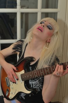Sexy blonde playing guitar
