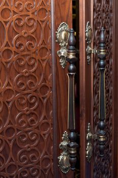 Handles on the old wooden door with carving