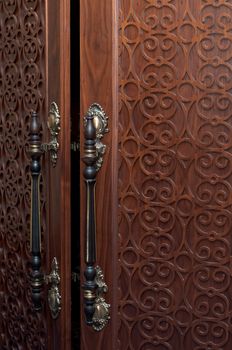 Handles on the old wooden door with carving