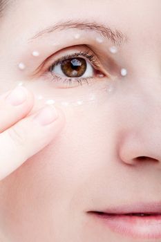 Beauty women applying female eye skin makeup cream