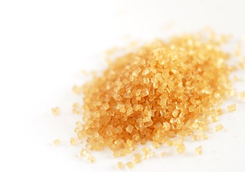 heap of yellowish brown sugar over white background