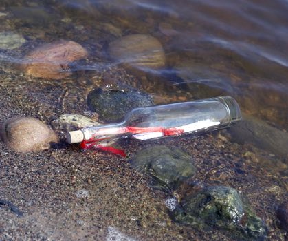 Message in a bottle at the edge of the water