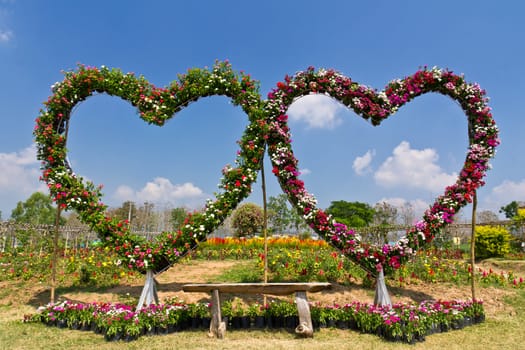 Floral love seat bench in flower garden