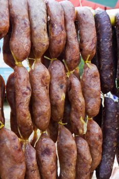 Home made meat salami sausage at street market hanging in line under sunlight to make good tasty