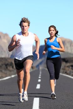 Running couple. Runners outdoor jogging workout on road beautiful landscape. Fit athletes training, Caucasian man, Asian woman.