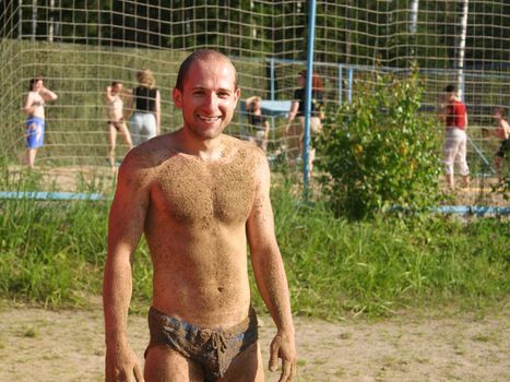 Men in sand and people on sea beach at vacations