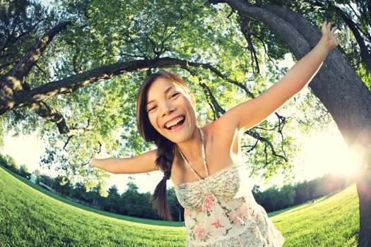 Playful woman in spring having fun in park smiling happy playing joyful. Beautiful young multicultural woman outside on sunny day.