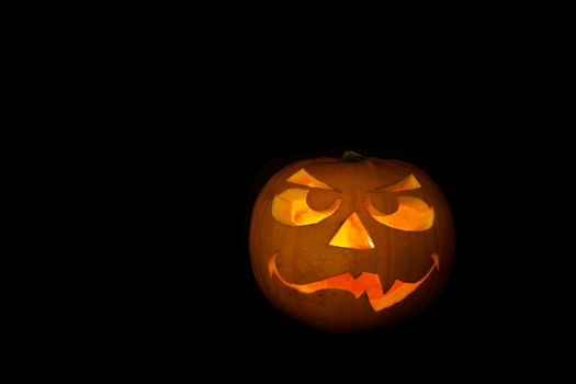 ghastly halloween pumpkin on black background