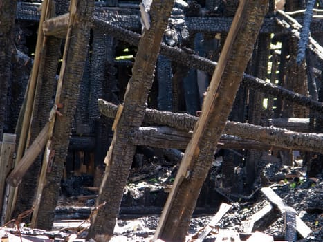 Ruined wood log house burnt by fire to black coal