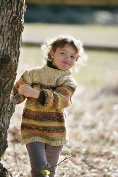 Young girl playing amongst the trees