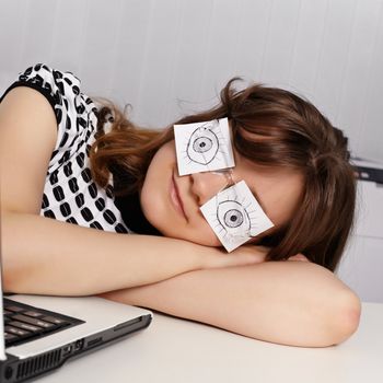 A young woman sleeps in the office during working hours