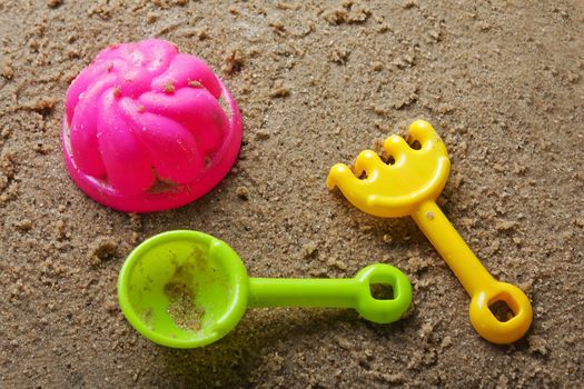 Plastic sandbox child toy on summer beach sand