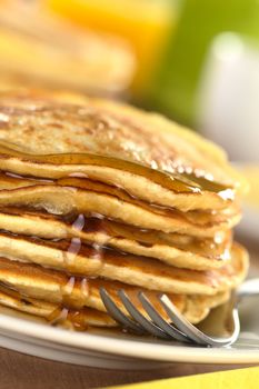 Fresh homemade pancakes with maple syrup (Selective Focus, Focus on the syrup drop running down)