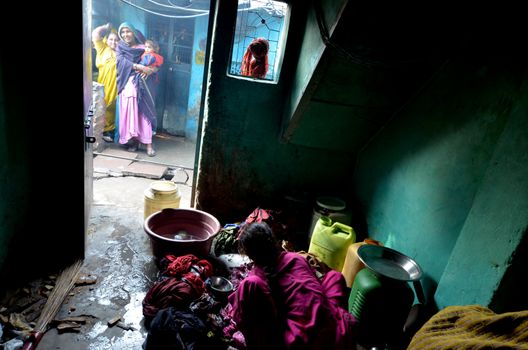New Delhi,India-February 4, 2013:An unidentified woman washing clothes in her home in the slum on February 4,2013 in New Delhi. 17 million residents do not have access to city water