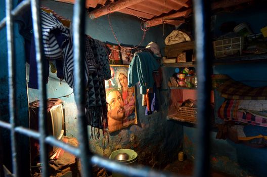 New Delhi,India-February 4, 2013:inside of a room with hung the figure of Jesus in the slum on February 4,2013 in New Delhi.The people of various religions pacifically cohabit, Christianity,Hinduism, Islam, Buddhism.