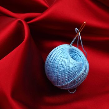 thread on red silk isolated close up